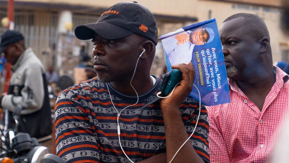 A supporter of incumbent President Felix Tshisekedi follows the publication of the provisional election results on his phone, in Lubumbashi, in the south of the Democratic Republic of Congo on December 31, 2023