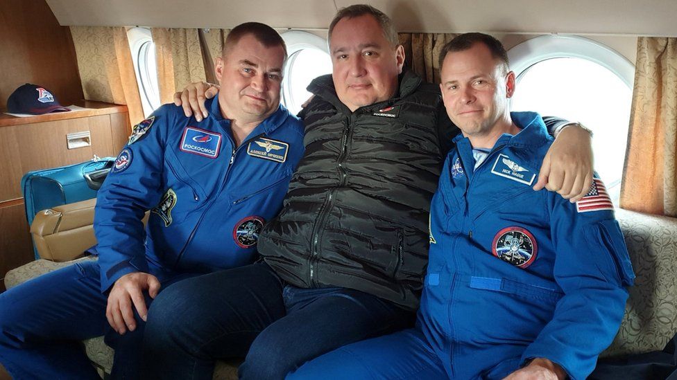Roscosmos Dmitry Rogozin (C) poses with astronauts Alexey Ovchinin of Russia and Nick Hague of the U.S., who survived the mid-air failure of a Russian rocket, on onboard a plane during a flight to Chkalovsky airport near Star City outside Moscow, Russia October 12, 2018