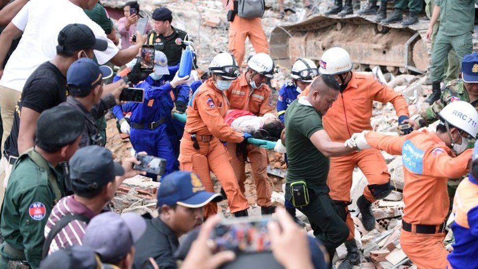 A rescue team carries a wounded worker from the collapsed building in Sihanoukville.