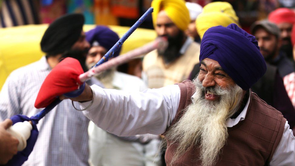 A man performing Gatka - the Sikh martial art - as part of a procession in Amritsar