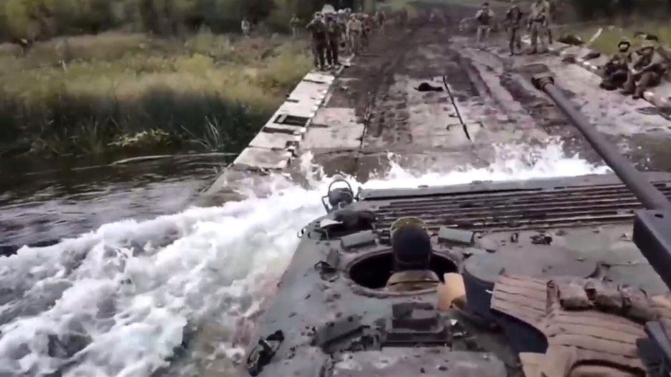 A Ukrainian troop carrier is seen crossing a river in eastern Ukraine