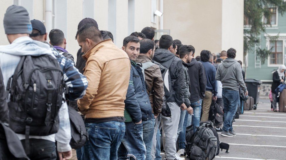 Migrants queue in front of a refugee reception centre in Tornio, Finland on 25 September 2015