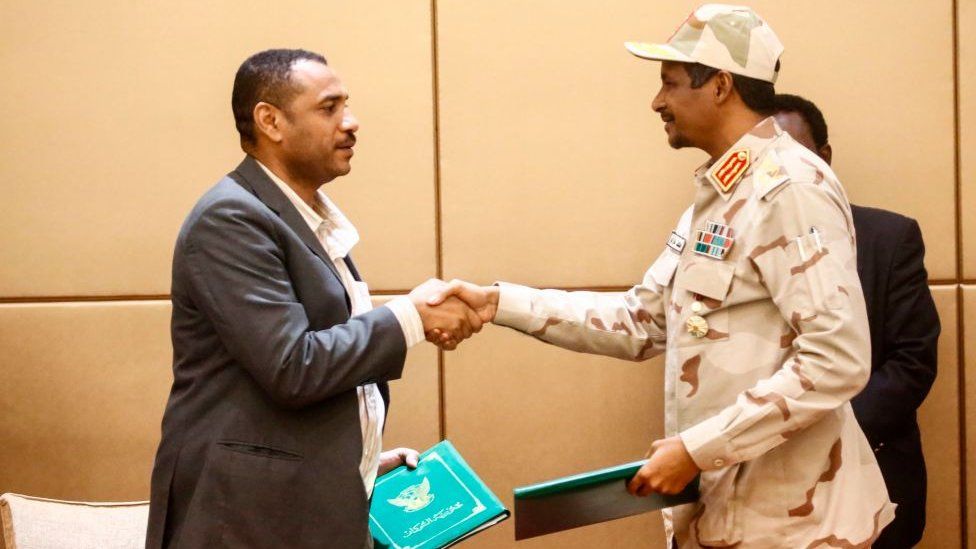 General Mohamed Hamdan Daglo (R), Sudan's deputy head of the Transitional Military Council, and protest leader Ahmed Rabie shake hands after signing the constitutional declaration