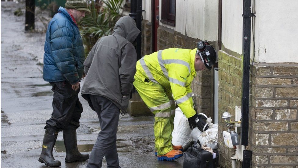 Residents lay sandbags down outside their homes in Mytholmroyd, West Yorkshire in preparation for the storm