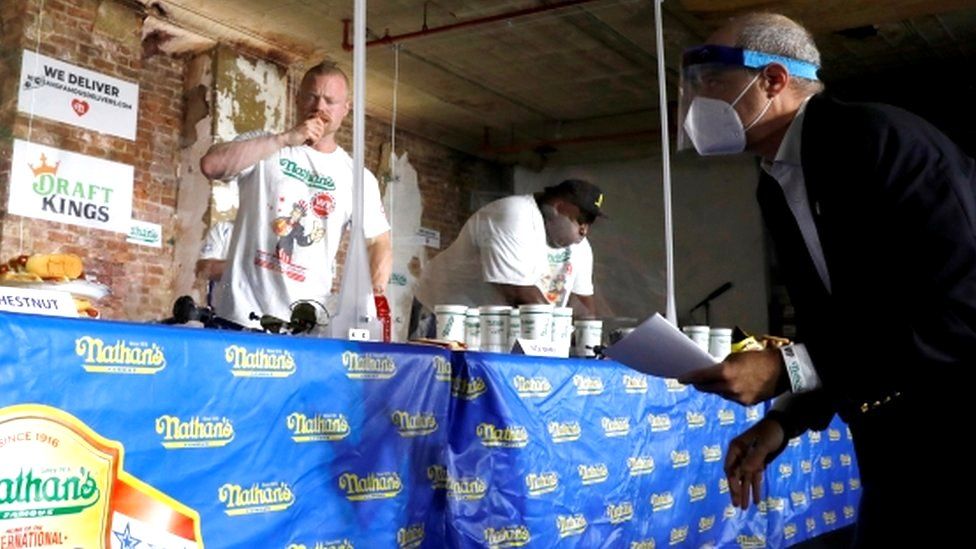 Мужчины соревнуются в Международном конкурсе по поеданию хот-догов Nathan's Famous Four of July в Бруклине, Нью-Йорк