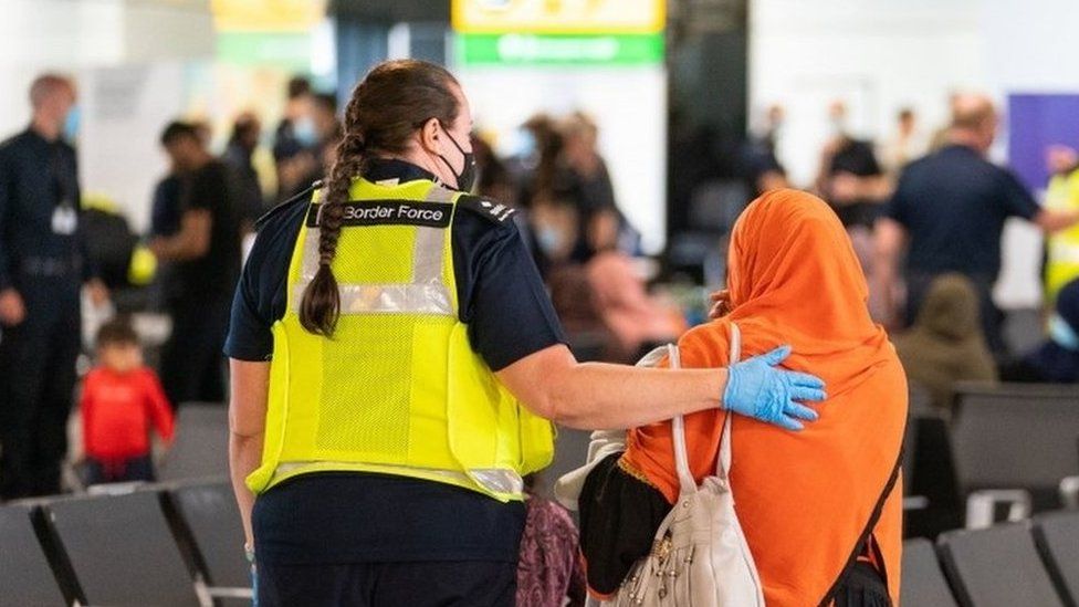 Border force officer escorts refugee