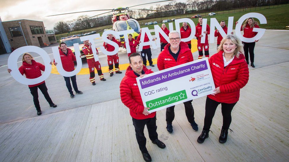 Midlands air ambulance staff holding outstanding sign