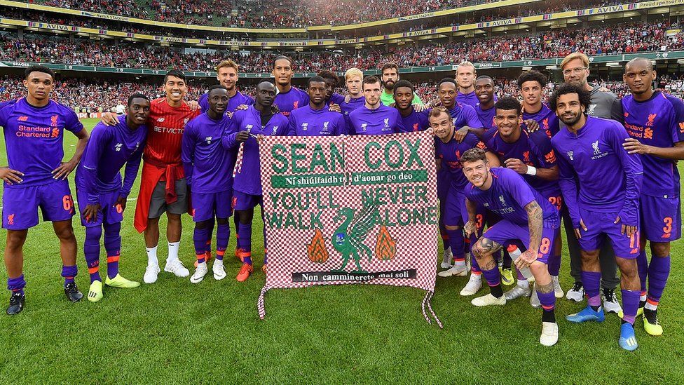 Liverpool players and Jurgen Klopp manager of Liverpool hold a banner for Sean Cox the Liverpool fan who has recently awoken from a coma after being injured at a Liverpool match at the end of the pre season friendly match between Liverpool and Napoli