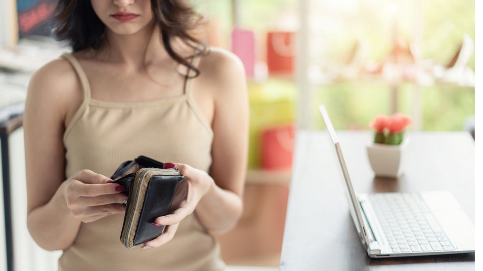 Woman looks in purse - stock shot