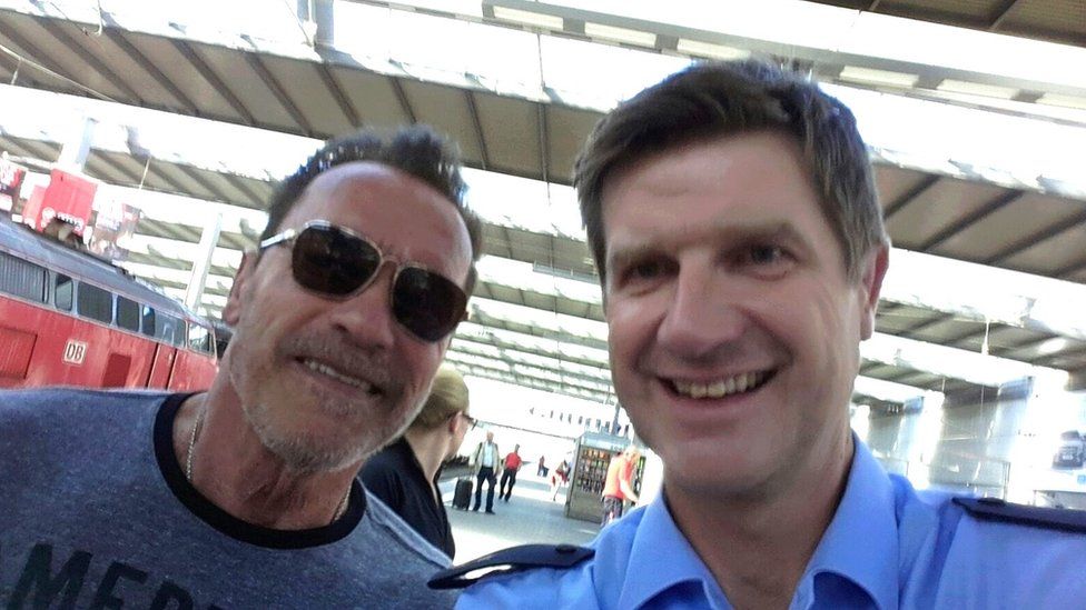 Arnold Schwarzenegger takes a selfie with officer Stefan Schmidt