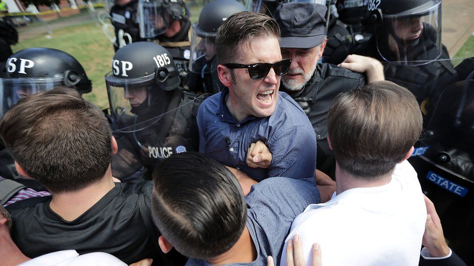 Richard Spencer wears glasses and is tousling with police