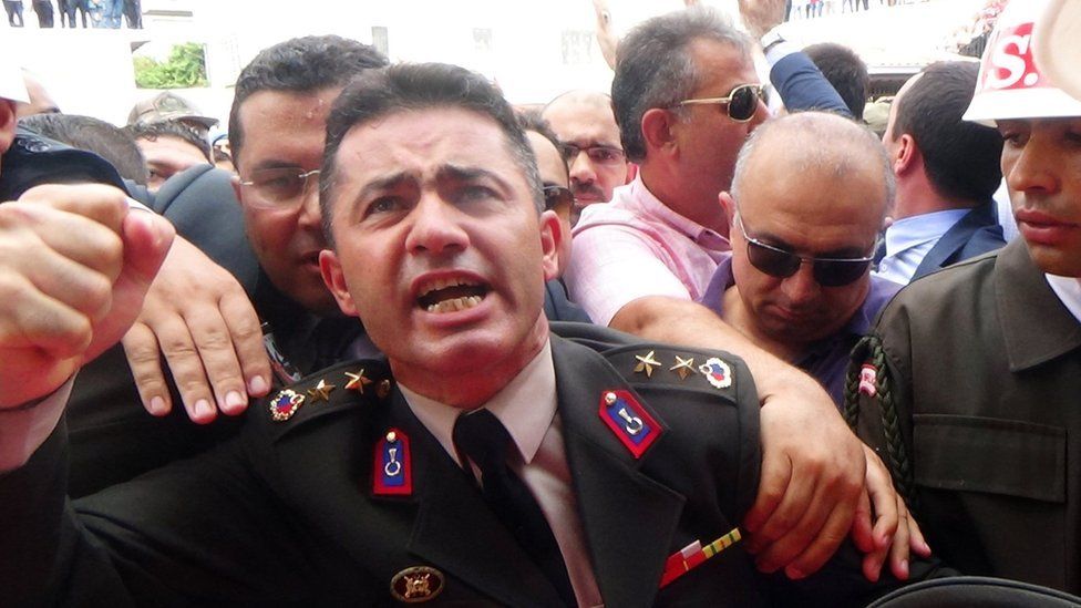 Lt Col Mehmet Alkan gestures during the funeral of his brother, Captain Ali Alkan, on 23 August 2015 in Osmaniye