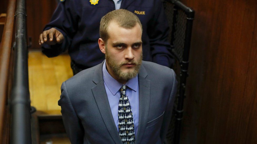 Henri van Breda being led away after being sentenced to three life terms by a judge