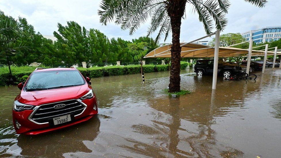 Vehicles are parked in a flooded parking lot following torrential rain in the Gulf Emirate of Dubai on April 16, 2024.