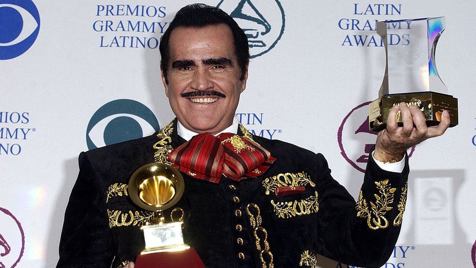 Vicente Fernández holding up some of the Latin Grammy Awards he as won