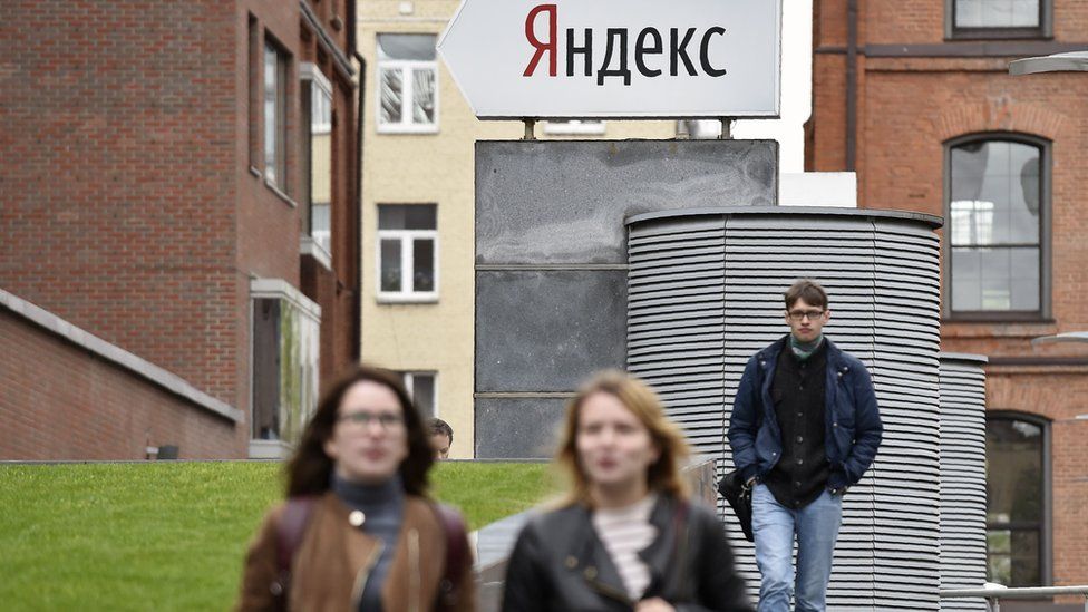 People walk outside the headquarters of Yandex, Russia's internet search engine, in Moscow, 16 May