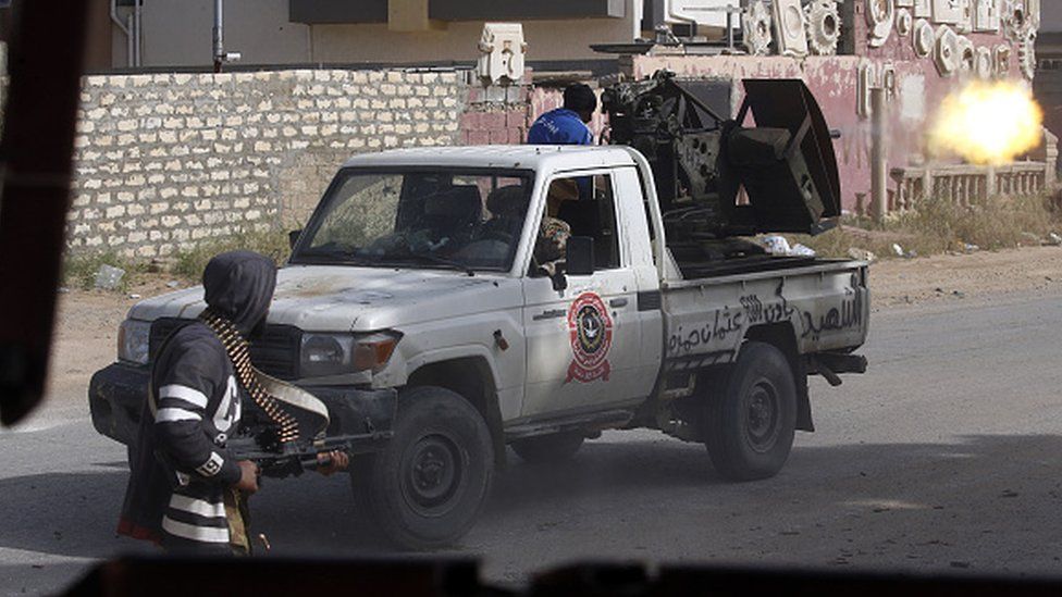 A Libyan fighter loyal to the Government of National Accord (GNA) fires a truck-mounted gun during clashes