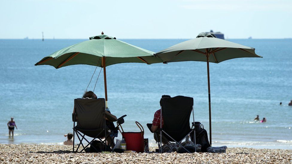 People enjoy the warm weather on Southsea Beach in Hampshire