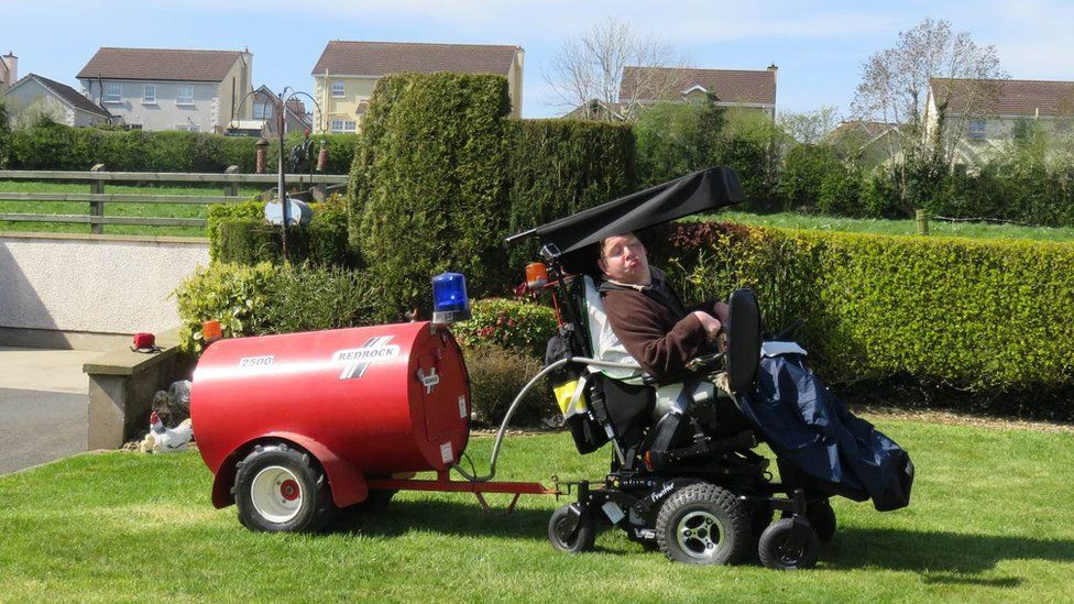 Jonathan Turtle uses his wheelchair to tow a slurry spreader