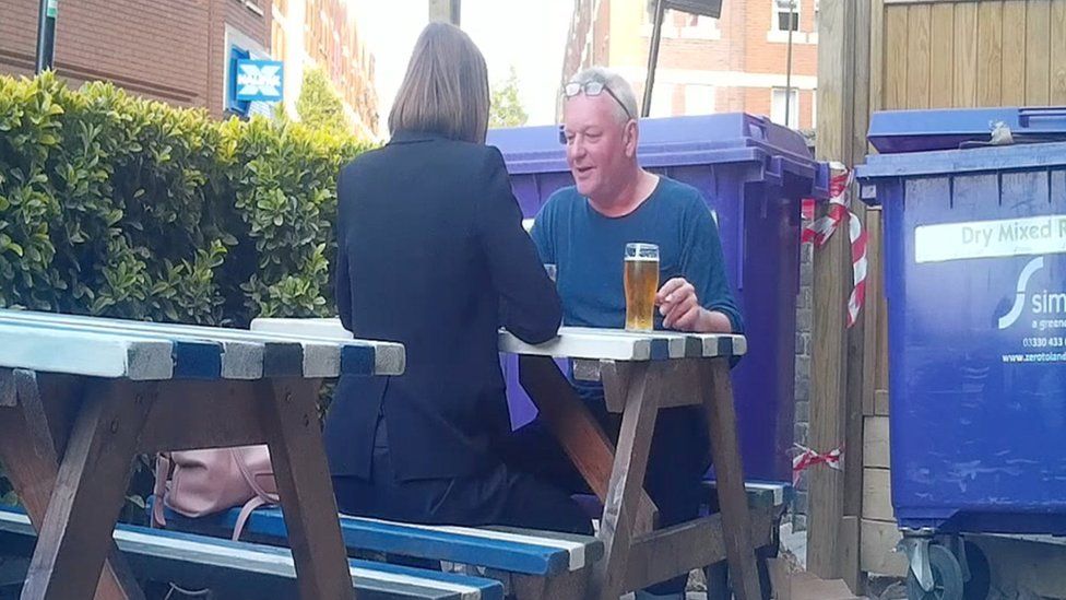 Julian Eden sitting on a park bench in a pub, speaking to Panorama's undercover reporter