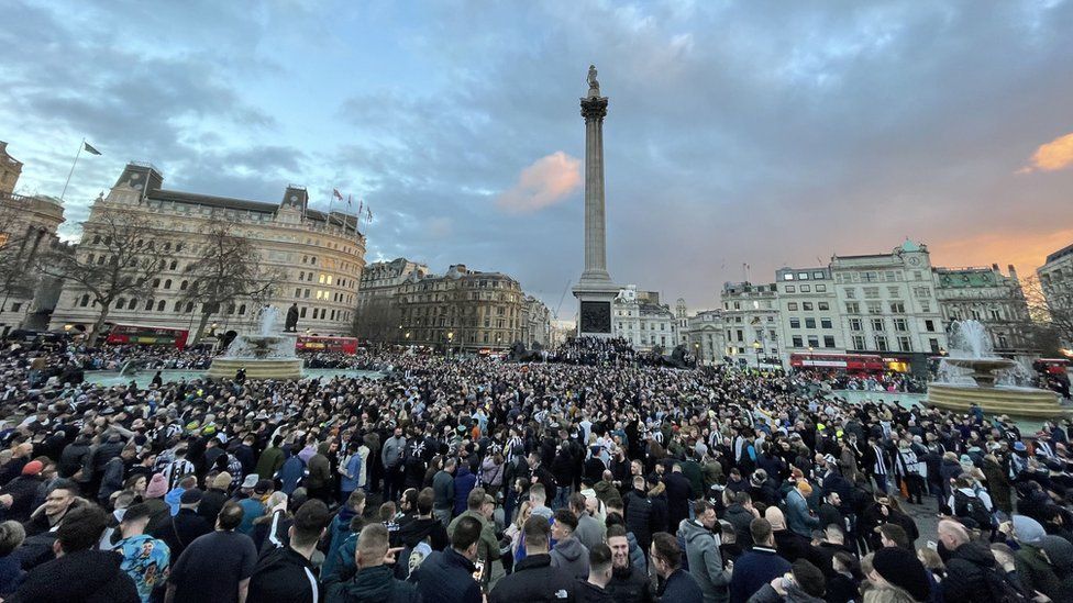 The sunset over a sea of thousands of people in Trafalgar Square