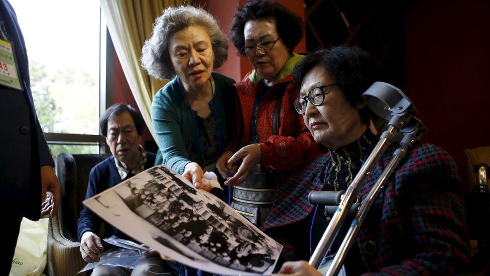South Korean participants for a reunion check old pictures at a hotel used as a waiting place in Sokcho, South Korea (19 October 2015)
