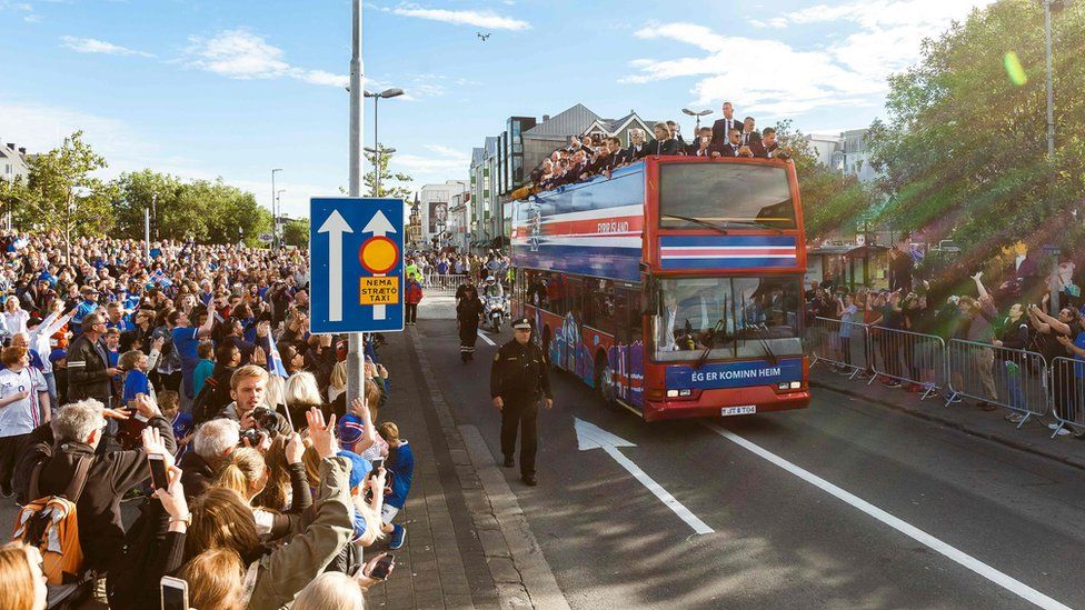 Iceland national football team arrives in Reykjavik on July 4, 2016 on a bus while people in the streets greet them as winners after they lost against France during the the Euro 2016 quarter-final football match between France and Iceland on the day before.
