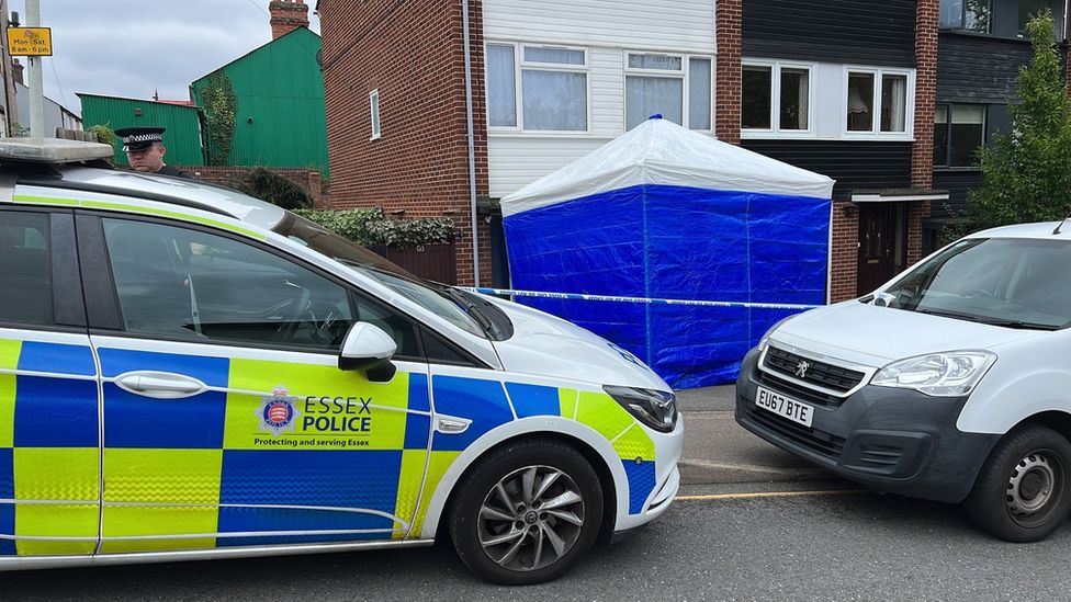 A police car and white van outside a property in Great Baddow. A blue and white police tent is outside.