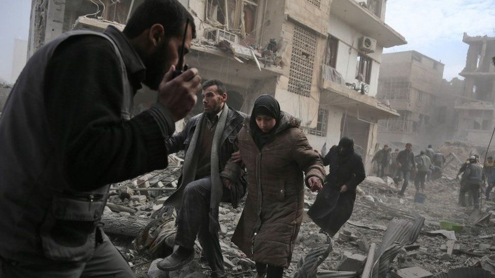Civilians flee from an area hit by a reported regime air strike in the besieged Eastern Ghouta region,