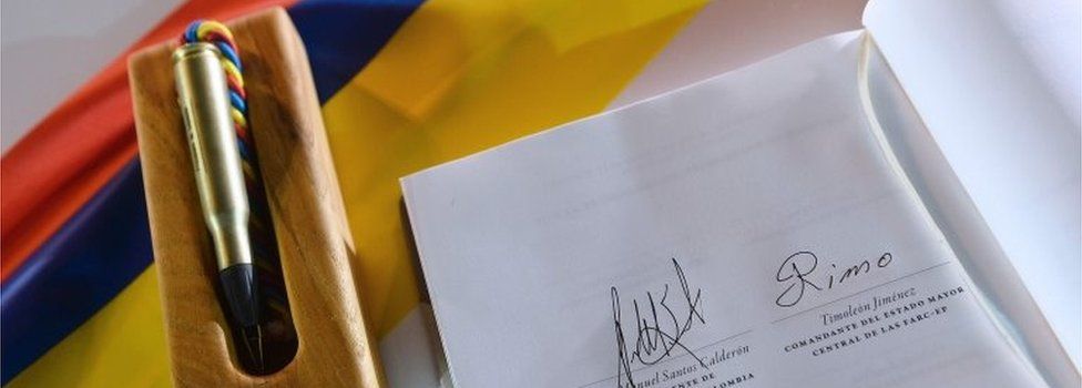 Handout picture released by the Colombian Presidency showing the document of the peace agreement with the signatures of Colombian President Juan Manuel Santos (R) and of the leader of the FARC, Rodrigo Londono, aka Timoleon "Timochenko" Jimenez , in Cartagena, Colombia, on September 26, 2016