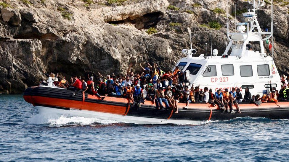 Мигранты прибывают на судно итальянской береговой охраны после того, как их спасли в море, недалеко от сицилийского острова Лампедуза, Италия, 1 сентября