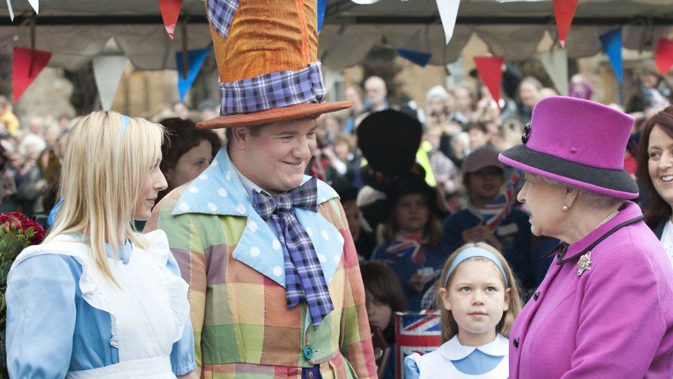 Queen meets schoolchildren at a Mad Hatter's Tea Party in a marquee on the lawn outside Sherborne Abbey