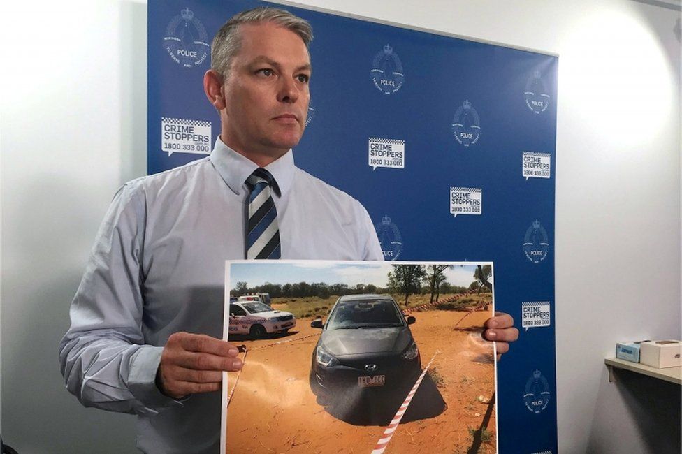Travis Wurst of the Northern Territory police with a photo of the crime scene