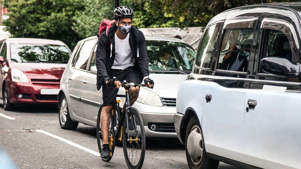 Cyclist riding on street with traffic jam