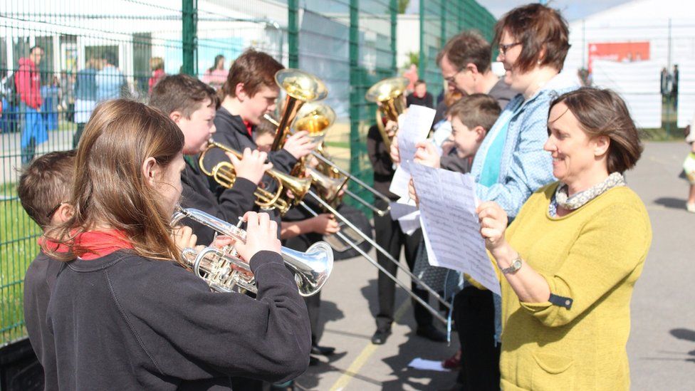 Band pres Ysgol Penweddig yn ymarfer ar y iard chwaraeon // Practice makes perfect for Ysgol Penweddig's brass band