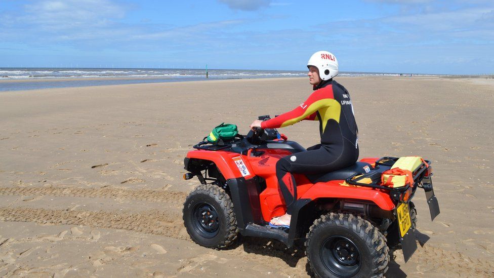 A RNLI lifeguard on a quad