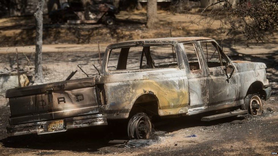 A burned out pick-up truck in a driveway as the Rocky fire burns near Clearlake, California (03 August 2015)