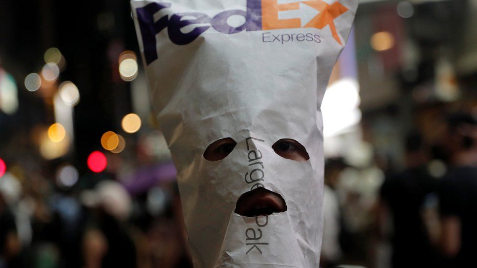 An anti-government protester wears a mask made with a FedEx envelope