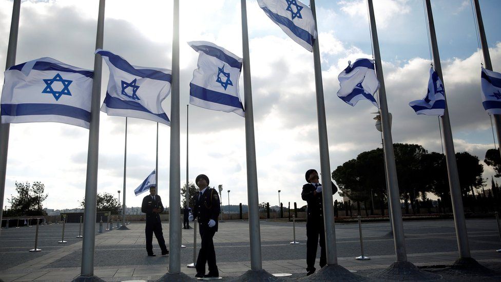 Members of the Knesset guard stand next to the Israeli flag at half-staff in preparations to display the coffin of former Israeli President Shimon Peres at the Knesset in Jerusalem