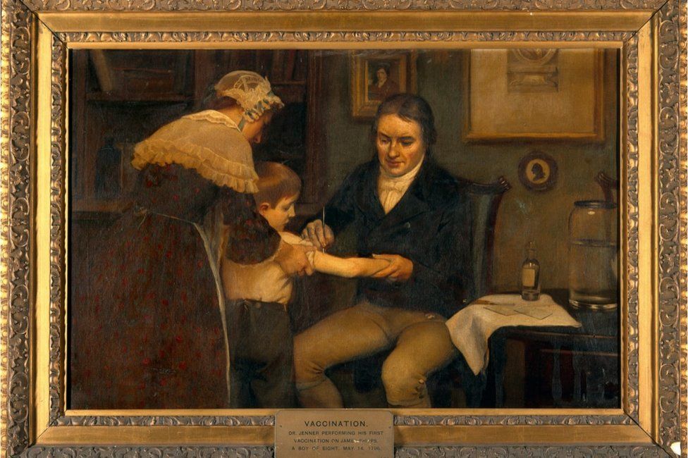Oil painting in a gold frame depicting Edward Jenner administering his first vaccination to a young boy James Phipps