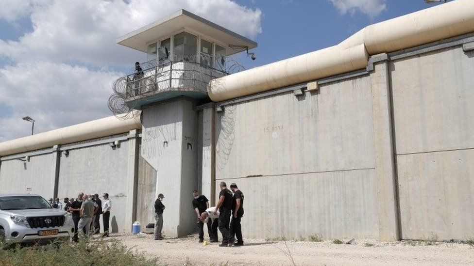 Israeli police and security personnel stand near evidence markers outside Gilboa Prison, northern Israel (6 September 2021)