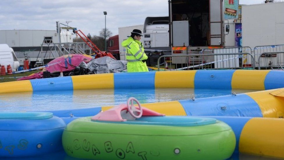 Police at the scene where a seven-year-old girl died after she was blown around 150 metres on a bouncy castle, which is thought to have been swept away by a sudden gust of wind at an Easter fair.