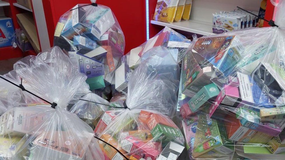 Coloured packaging visible inside several large bin bags