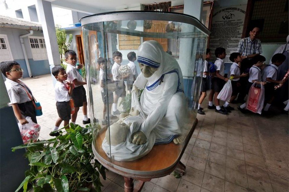 School children stand in a queue past a statue of Mother Teresa as they arrive to visit the Nirmala Shishu Bhavan, a children's home founded by Mother Teresa, ahead of Mother Teresa"s canonization ceremony in Kolkata, India August 30, 2016.