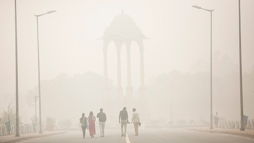 People walk near India gate amid heavy dust and smog November 7, 2016 in Delhi