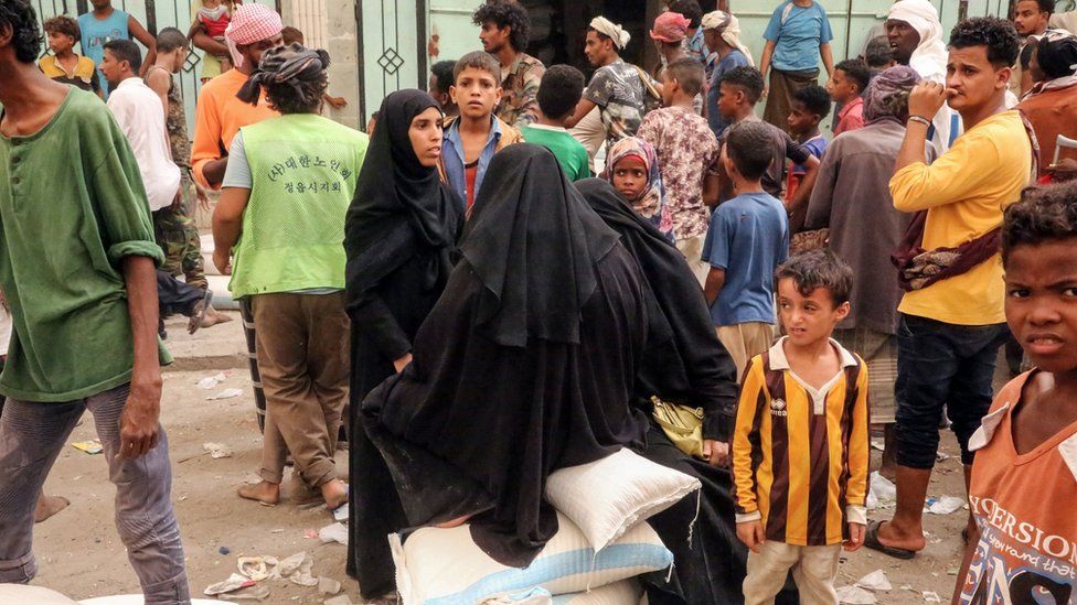 Yemeni women stand beside food aid in the city of Hudaydah (14 June 2018)