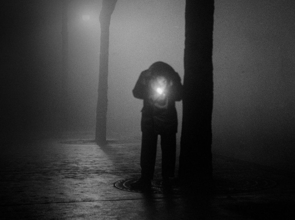 Man lighting a cigarette, Paris 1950