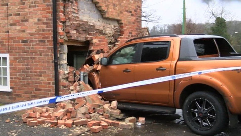 Truck embedded into the wall of the house