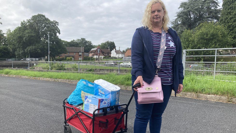 Sarah Rogers with a trolley full of shopping the street