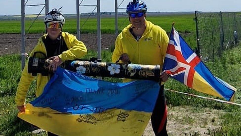 Karol Swiacki And Laurie Robertson holding flags on the Ukraine Border